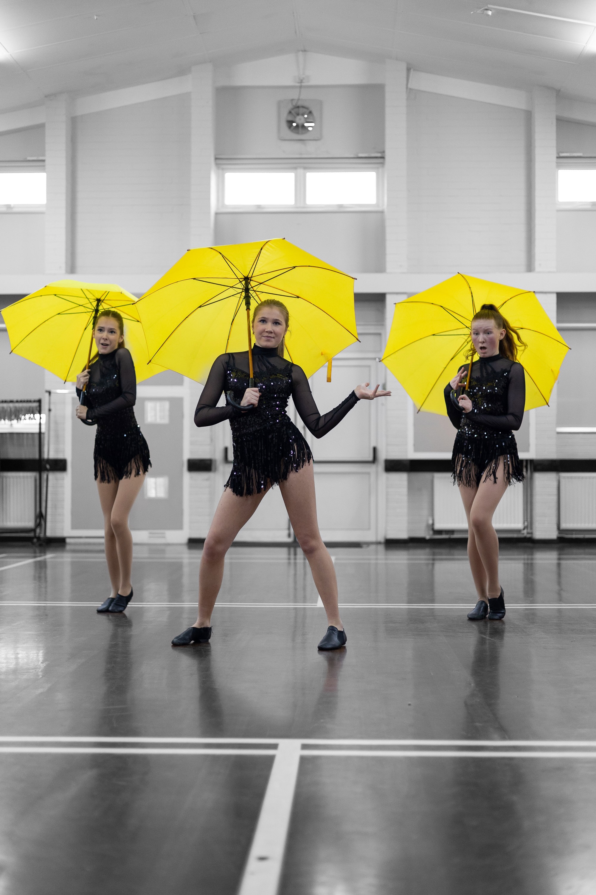 Three dancers with yellow umbrellas, selective colour